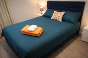a bedroom with a blue bed with two towels on it at Chill Haven in Kingston