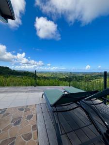 a chair sitting on top of a patio with a view at Residence la Floride in Gros-Morne