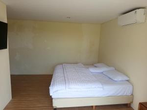 a bedroom with a bed with white sheets and pillows at villa reyray in Jimbaran