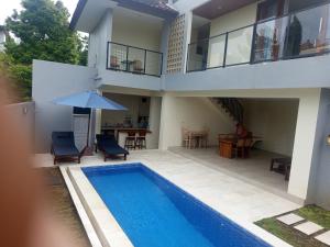 a villa with a swimming pool and a house at villa reyray in Jimbaran