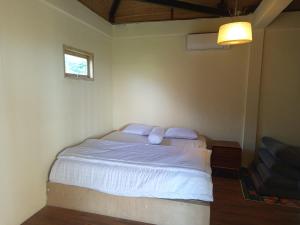 a bedroom with a bed with two pillows and a window at villa reyray in Jimbaran