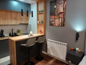 a kitchen with a bar with two stools in it at The Little Haven in Kragujevac