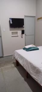 a room with a bed and a tv on a wall at Hotel villa in Montería