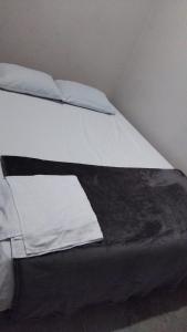 a bed with white sheets and pillows on it at Hotel villa in Montería