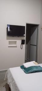 a flat screen tv on a wall above a bed at Hotel villa in Montería