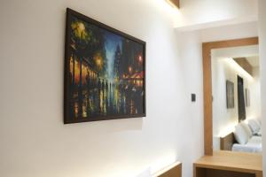 a painting hanging on a wall in a living room at Hotel Nature's Nest in Shirdi