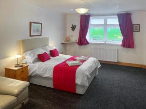 a bedroom with a bed with a red blanket at West Tannacrieff in Stewarton