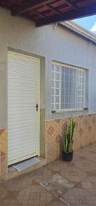a door to a house with a plant in front of it at Quarto Aconchegante com Wi-Fi self check-in e garagem in Pouso Alegre +6 photos