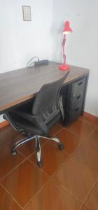 a desk with a chair with a desktop computer at Quarto Aconchegante com Wi-Fi self check-in e garagem in Pouso Alegre