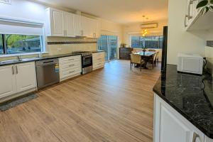 a kitchen with white cabinets and a dining room with a table at Home in Moe in Moe