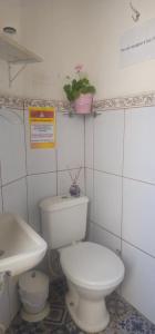 a bathroom with a white toilet and a sink at Quarto Aconchegante com Wi-Fi self check-in e garagem in Pouso Alegre