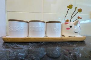 a shelf with three tea cups and a vase at Home in Moe in Moe