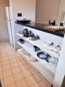 a kitchen with white shelves with dishes and a refrigerator at Duplex familiar zona macrocentro in Resistencia +5 photos