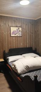 a bedroom with a bed with a wooden wall at Trysil turistesenter liten leilighet in Trysil