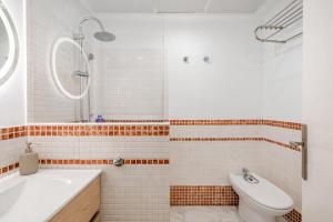 a bathroom with a tub and a sink and a toilet at Sofia Luxury Apartment in Seville +23 photos