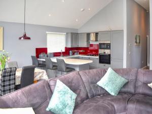 a living room with a couch and a kitchen at Oak Park Two - Uk50063 in Tiverton
