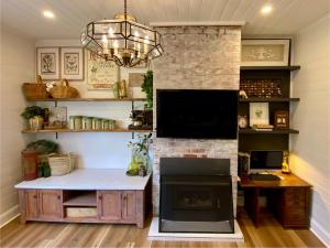 a living room with a fireplace and a television at Korumburra Farmhouse in Korumburra