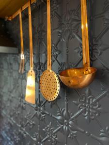 a group of kitchen utensils hanging from a wall at Korumburra Farmhouse in Korumburra +37 photos