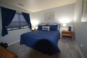 a bedroom with a bed with blue sheets and a window at Grant's Condo in The Greens in Branson