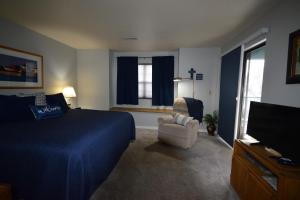 a bedroom with a bed and a chair and a television at Grant's Condo in The Greens in Branson