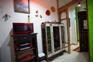 a living room with a tv and a cabinet at La Selva by Majikal B&B in Mérida