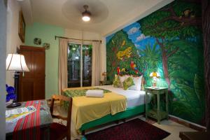 a bedroom with a painting on the wall at La Selva by Majikal B&B in Mérida +31 photos