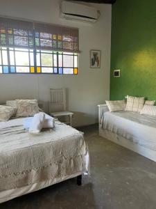 two beds in a room with green walls and windows at Los dos Algarrobos in Villa Dolores