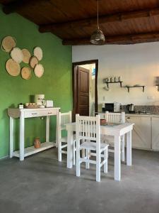 a kitchen with white tables and chairs in a room at Los dos Algarrobos in Villa Dolores