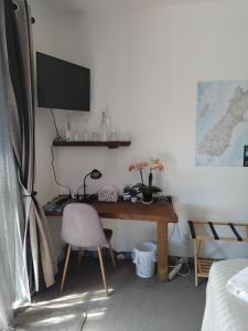 a desk with a chair and a computer on a wall at Al and Rosies B+B in Greymouth
