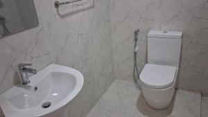 a bathroom with a white toilet and a sink at Layans Properties in Gampaha