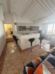 a living room with a couch and a kitchen at Villa Alejandro in Melgar