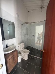 a bathroom with a shower and a toilet and a sink at Villa Alejandro in Melgar +3 photos