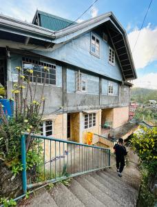 a man walking up the stairs of a house at Mama Lourdes Homestay in Sagada