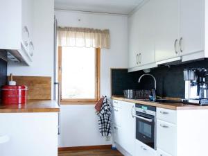 a kitchen with white cabinets and a window at 4 person holiday home in Nordkoster in Strömstad