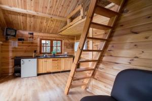 a kitchen with a staircase in a wooden cabin at Summer cottages in Kashubia in Gostkowo