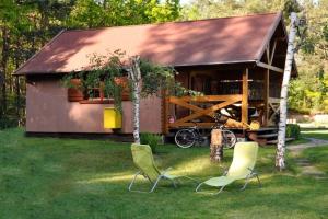 two chairs in front of a small building at Summer cottages in Kashubia in Gostkowo