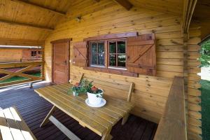 a wooden cabin with a table and a window at Summer cottages in Kashubia in Gostkowo