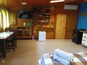 a room with a kitchen with a table and a refrigerator at Cabaña azul in Los Antiguos