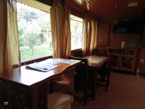 a dining room with two tables and a window at Cabaña azul in Los Antiguos