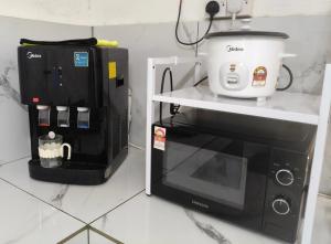 a microwave and a coffee maker on a counter at Halwa Homestay in Semporna