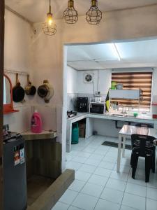 a kitchen with a table and a counter top at Halwa Homestay in Semporna +17 photos