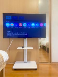 a flat screen tv on a stand in a room at AJITO Hostel 別館 in Shingū