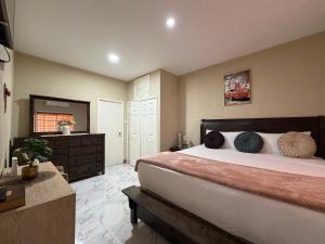 a bedroom with a bed and a dresser and a mirror at 360 RokView Suites 3BR Spacious in Kingston +20 photos