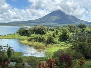 a mountain in the distance with a river and trees at Cabin Casove in El Castillo de La Fortuna +18 photos