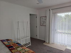 a bedroom with a bed and a ladder and a window at Marigold in Manurewa in Auckland