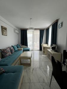 a living room with a blue couch and a table at Bilali Apartments in Ulcinj
