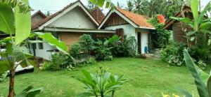 a house with a lawn in front of it at Rumah Gaharu - Kulon in Kalirejo