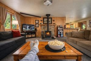 a person with their feet up on a coffee table in a living room at Bear Paw Cabin in Leavenworth