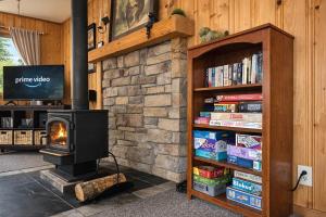 a fireplace in a living room with a book shelf with books at Bear Paw Cabin in Leavenworth +45 photos
