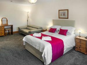 a bedroom with a large bed and a couch at West Tannacrieff in Stewarton